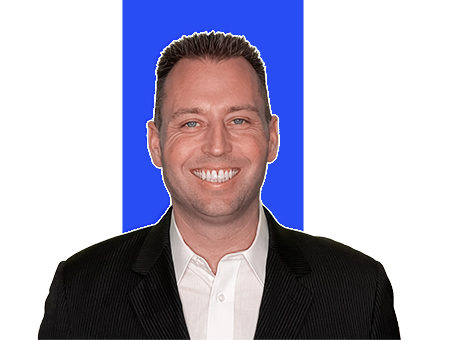 headshot of realtor Tony Anczer wearing a black suit jacket and white shirt with a white and blue background