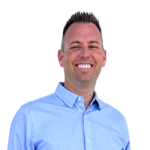 headshot of Realtor Tony Anczer. Tony is wearing a blue button-up shirt and there is a transparent background