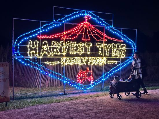 illuminated "harvest Tyme Famikly Farm" main entrance sign at night time at Harvest Tyme Family Farm "pumpkin glow" event