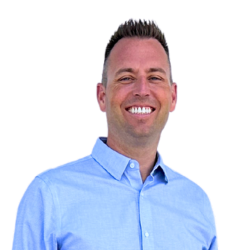 headshot of Realtor Tony Anczer. Tony is wearing a blue button-up shirt and there is a transparent background